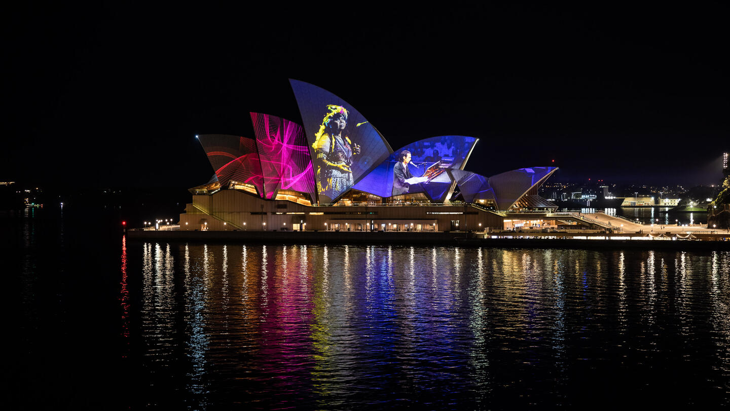 A photo of the Sydney Opera House with projections mapped across its sails  