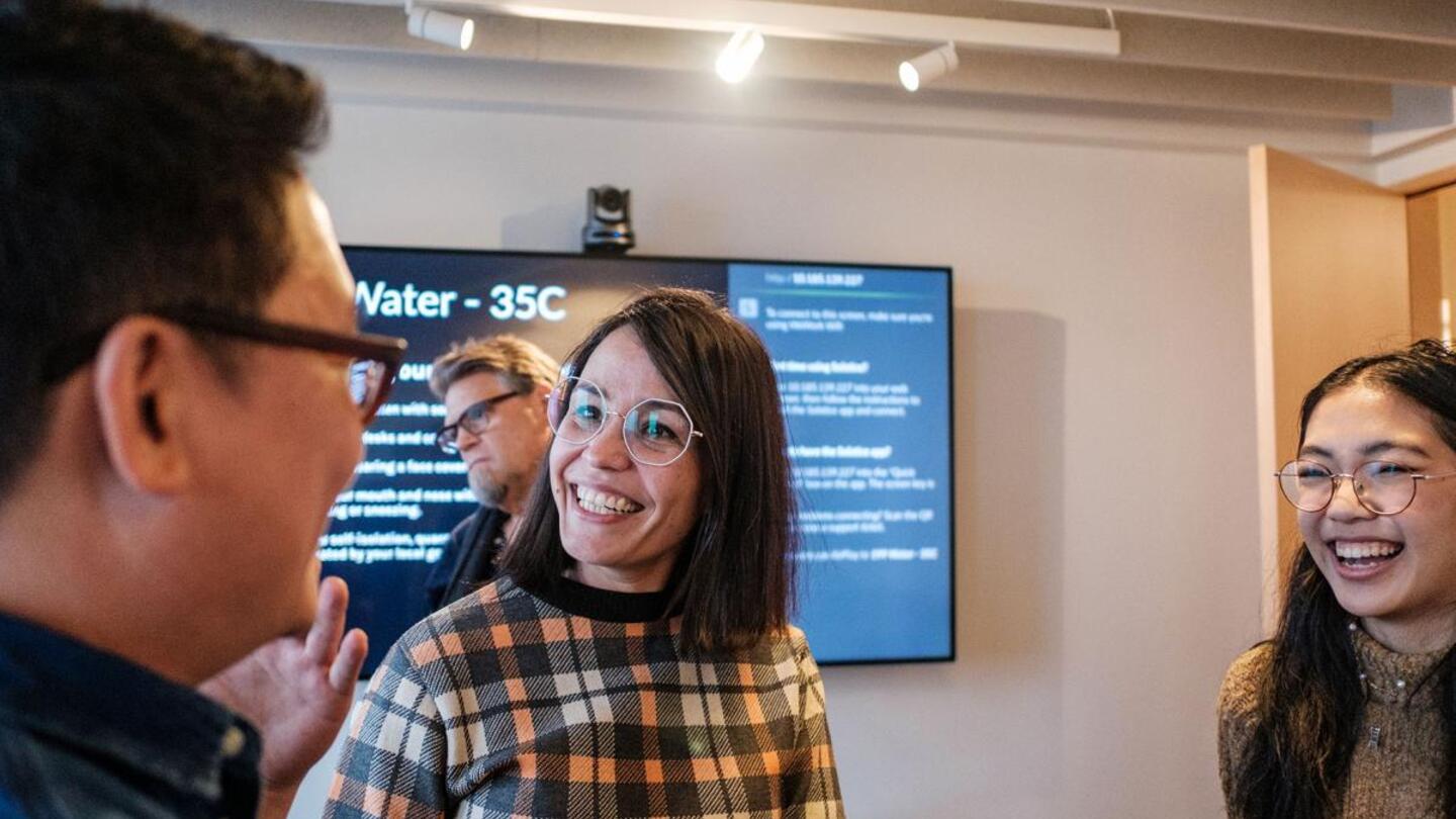 Group of people in smiling interaction at Sydney Exhibit