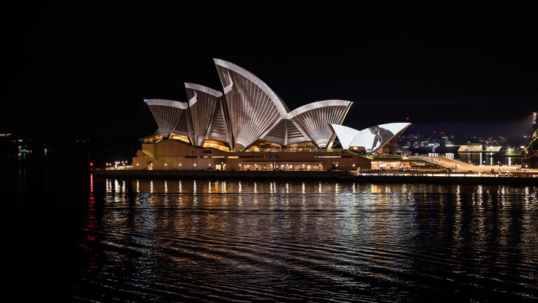 The Sydney Opera House at night, with projection mapping across its sails