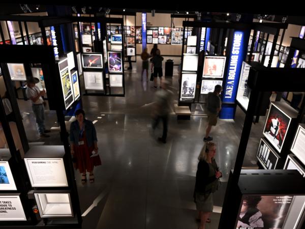 People walking around a gallery inside the Bob Dylan Center.