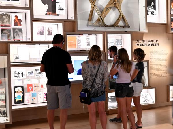 A group of people listening to audio delivered synchronously by the audio guide Art Processors developed for the Bob Dylan Center.
