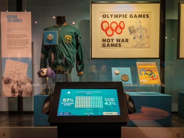 Showcase of sporting memorabilia at the Australian Sports Museum. A digital touch screen sits in front of the showcase