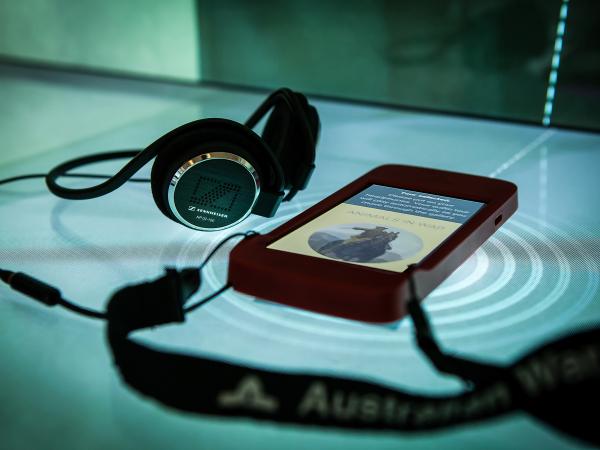 An iPod Touch with headphones on an interactive screen