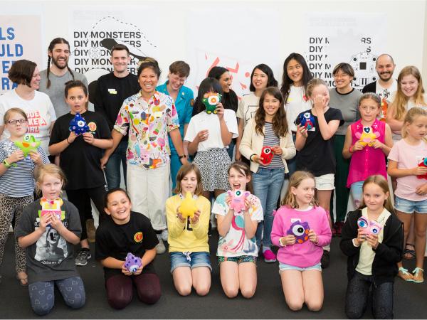 Photo of all participants and volunteers pose for a silly photo with their final monster creations.