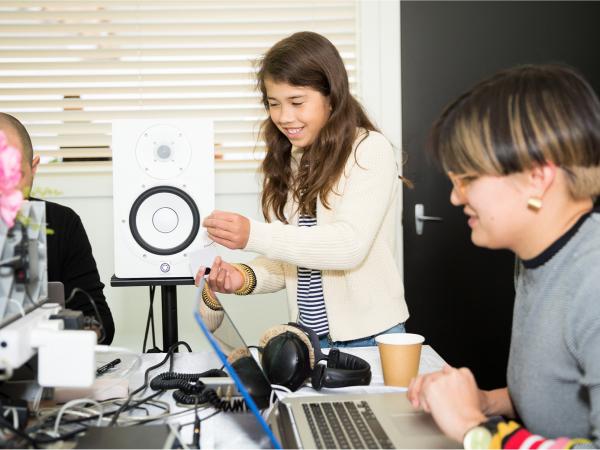 Two DIY Monster volunteers with a participant in the Sound Lab, recording custom monster sound onto sound chip with speaker.