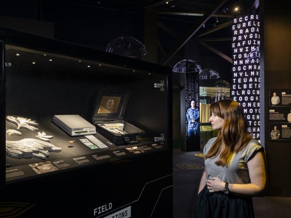A woman stands inside the Decoded exhibition at the National Museum of Australia.