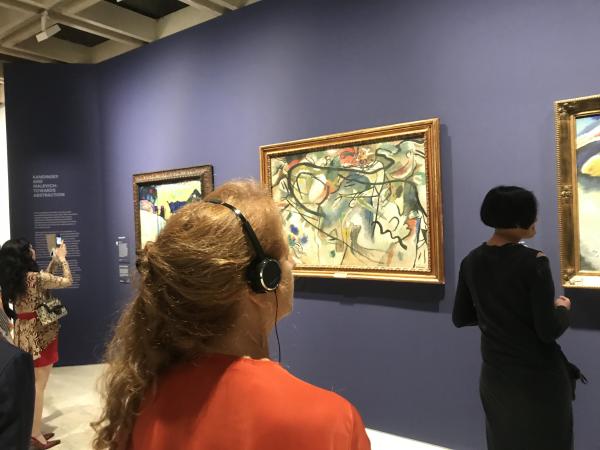 Visitor listening to audio guide at the Hermitage exhibition at the Art Gallery of NSW.