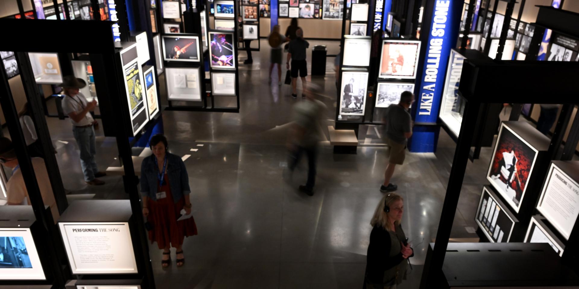People walking around a gallery inside the Bob Dylan Center.