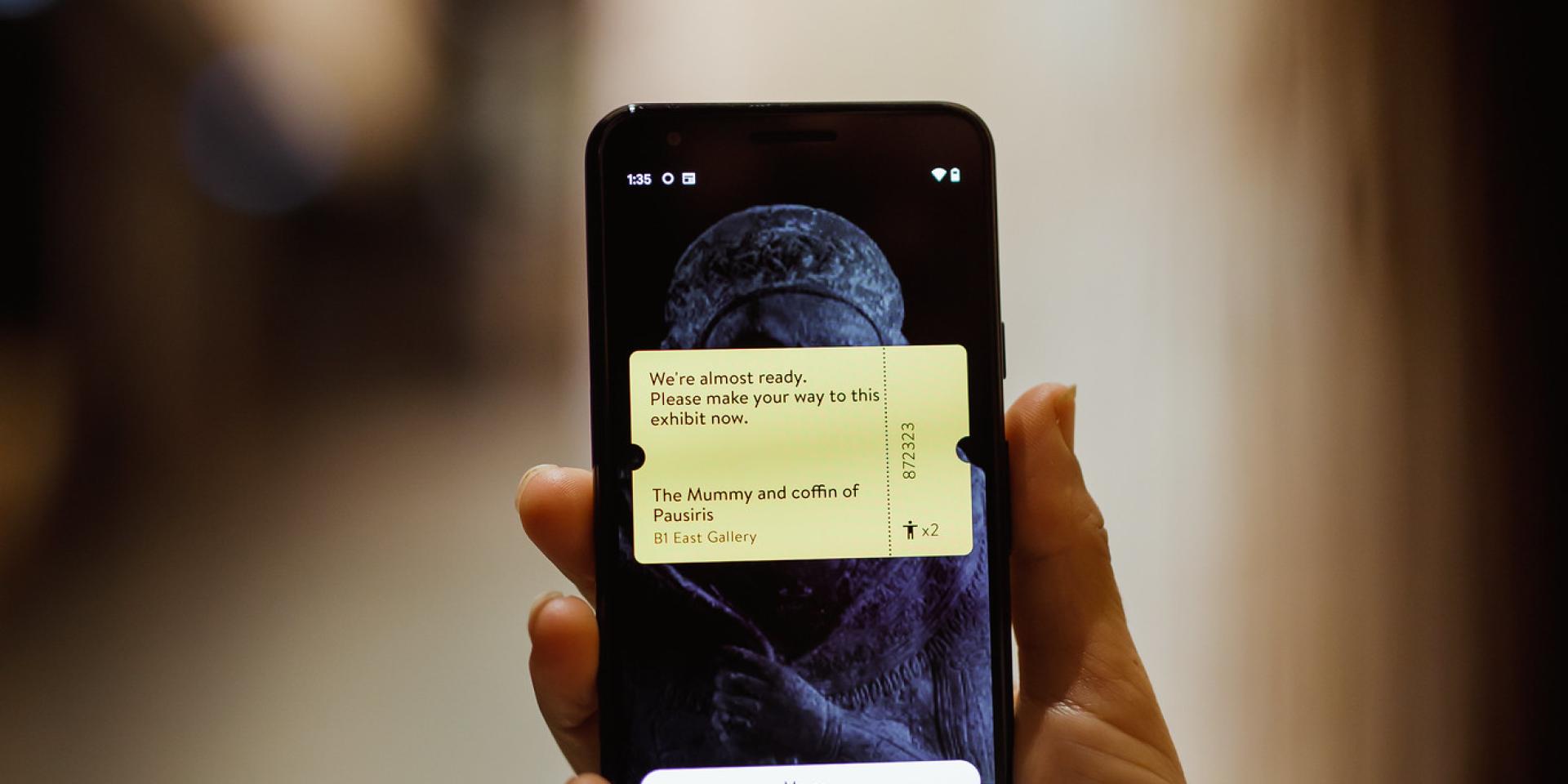 A person holding a mobile device displaying a virtual ticket.