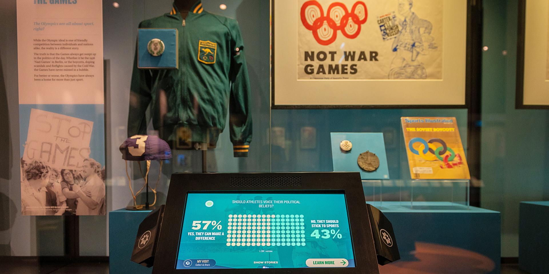Showcase of sporting memorabilia at the Australian Sports Museum. A digital touch screen sits in front of the showcase