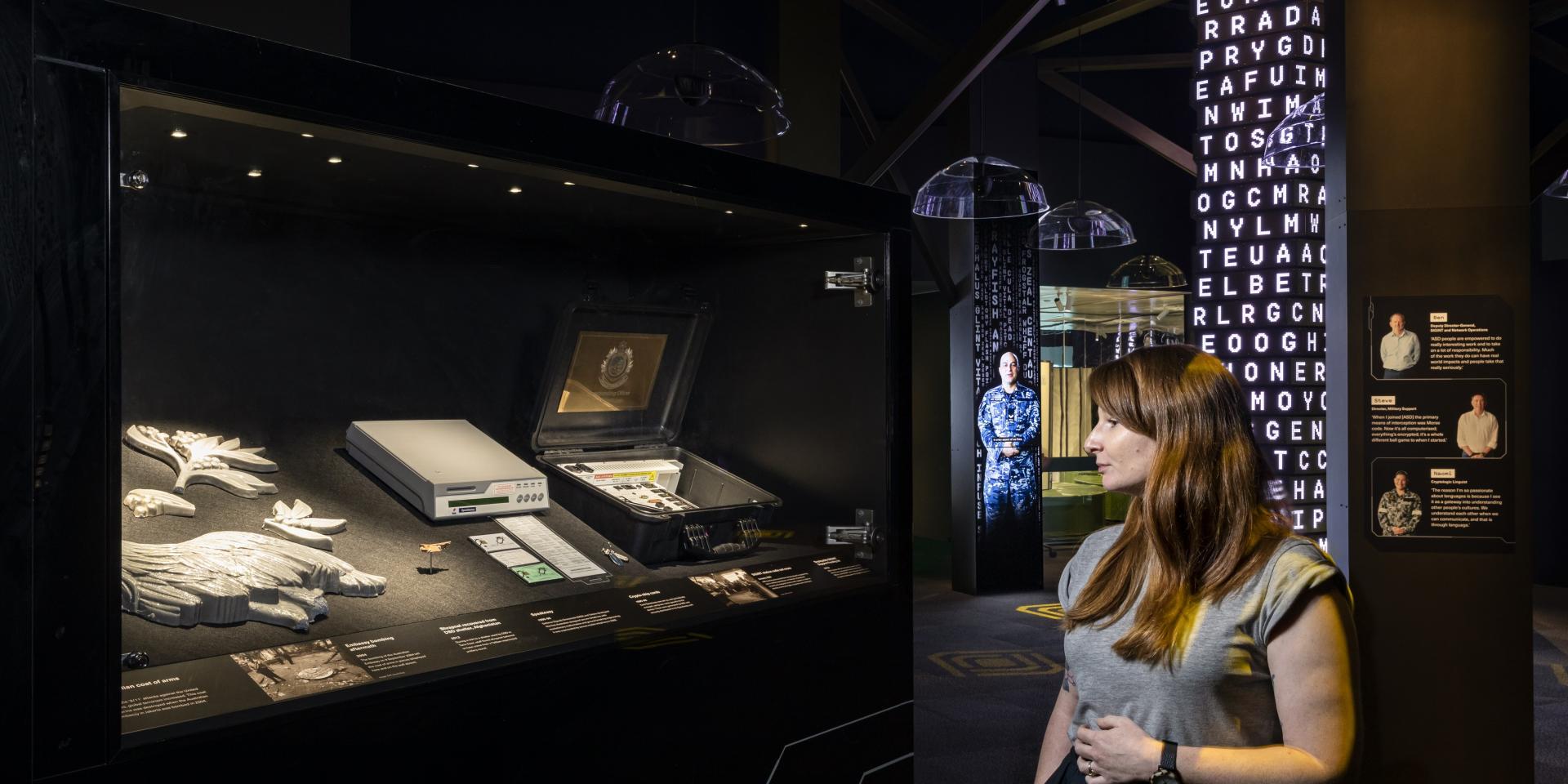 A woman stands inside the Decoded exhibition at the National Museum of Australia.