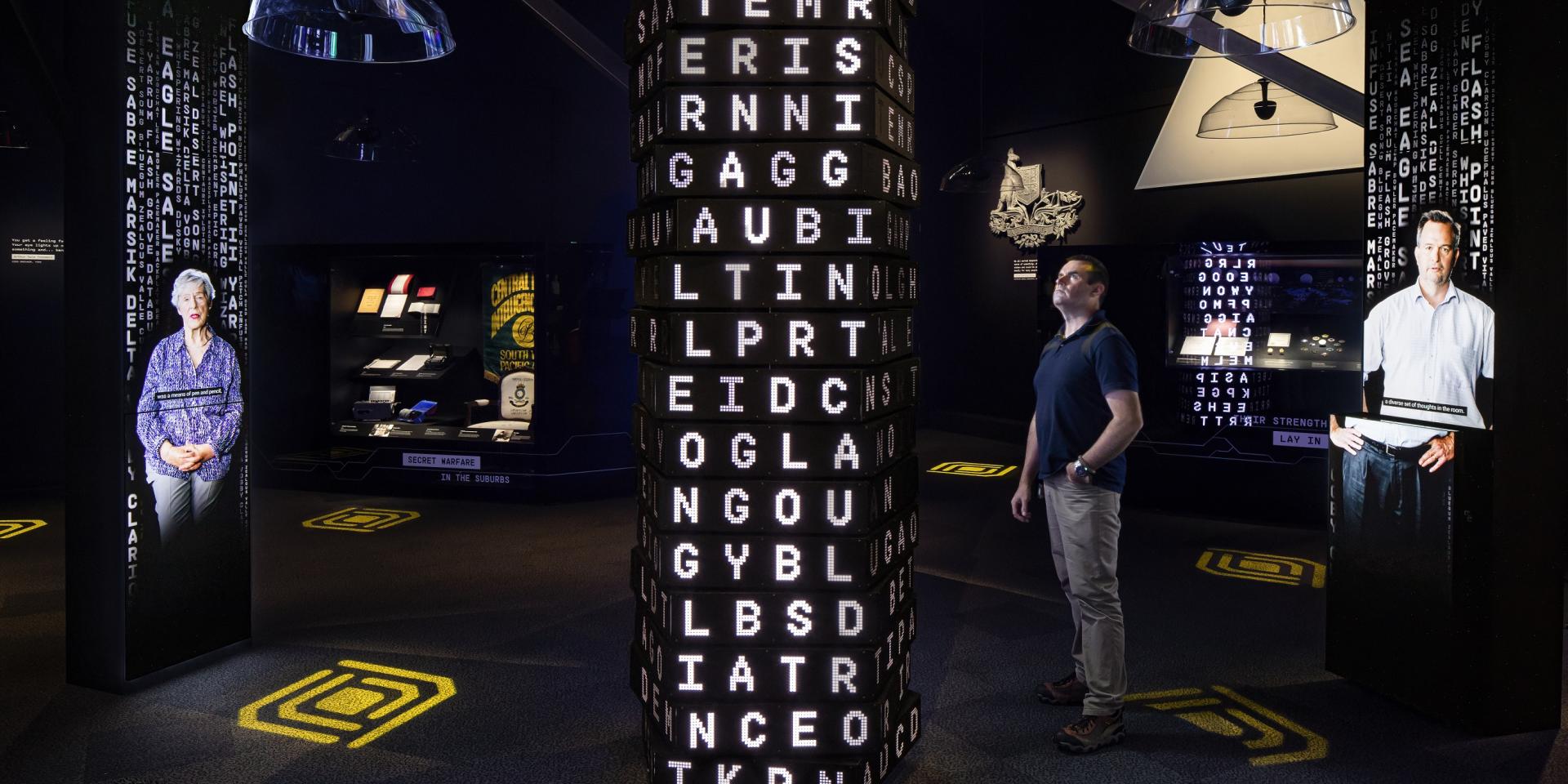 A man stands inside the Decoded exhibition at the National Museum of Australia.