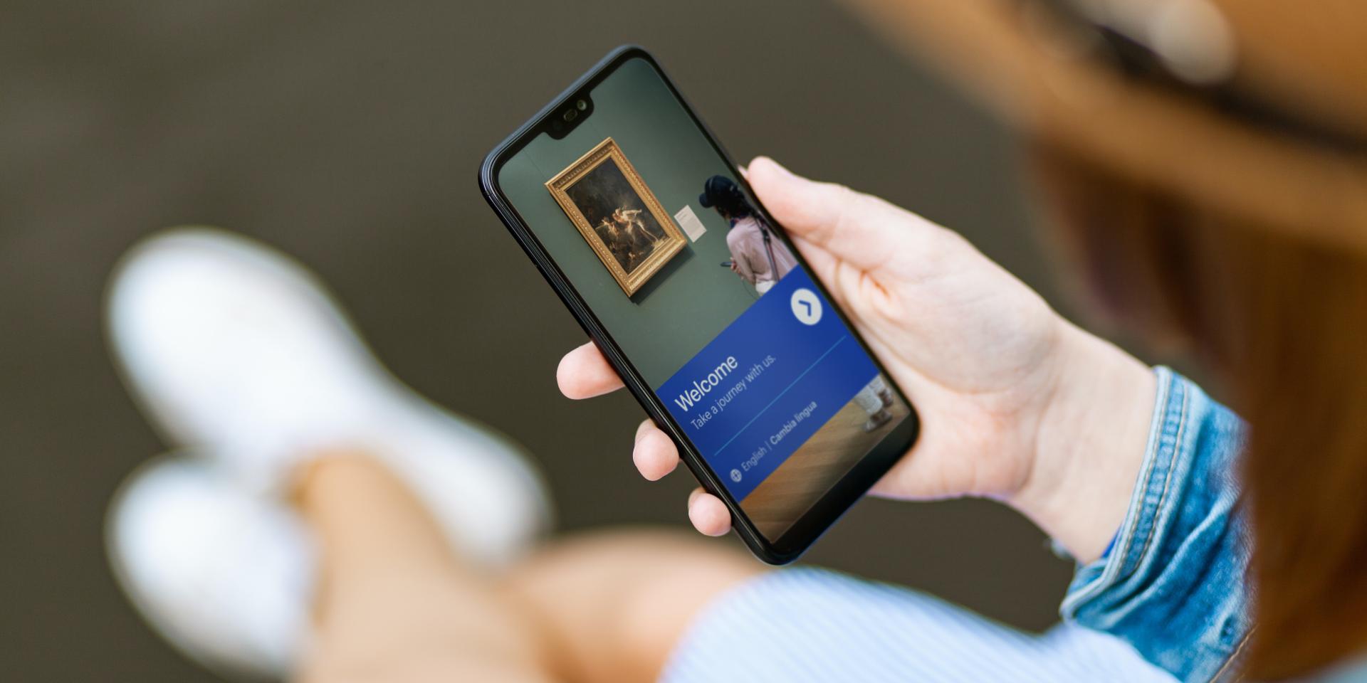 Person holds a mobile device displaying the GettyGuide app.