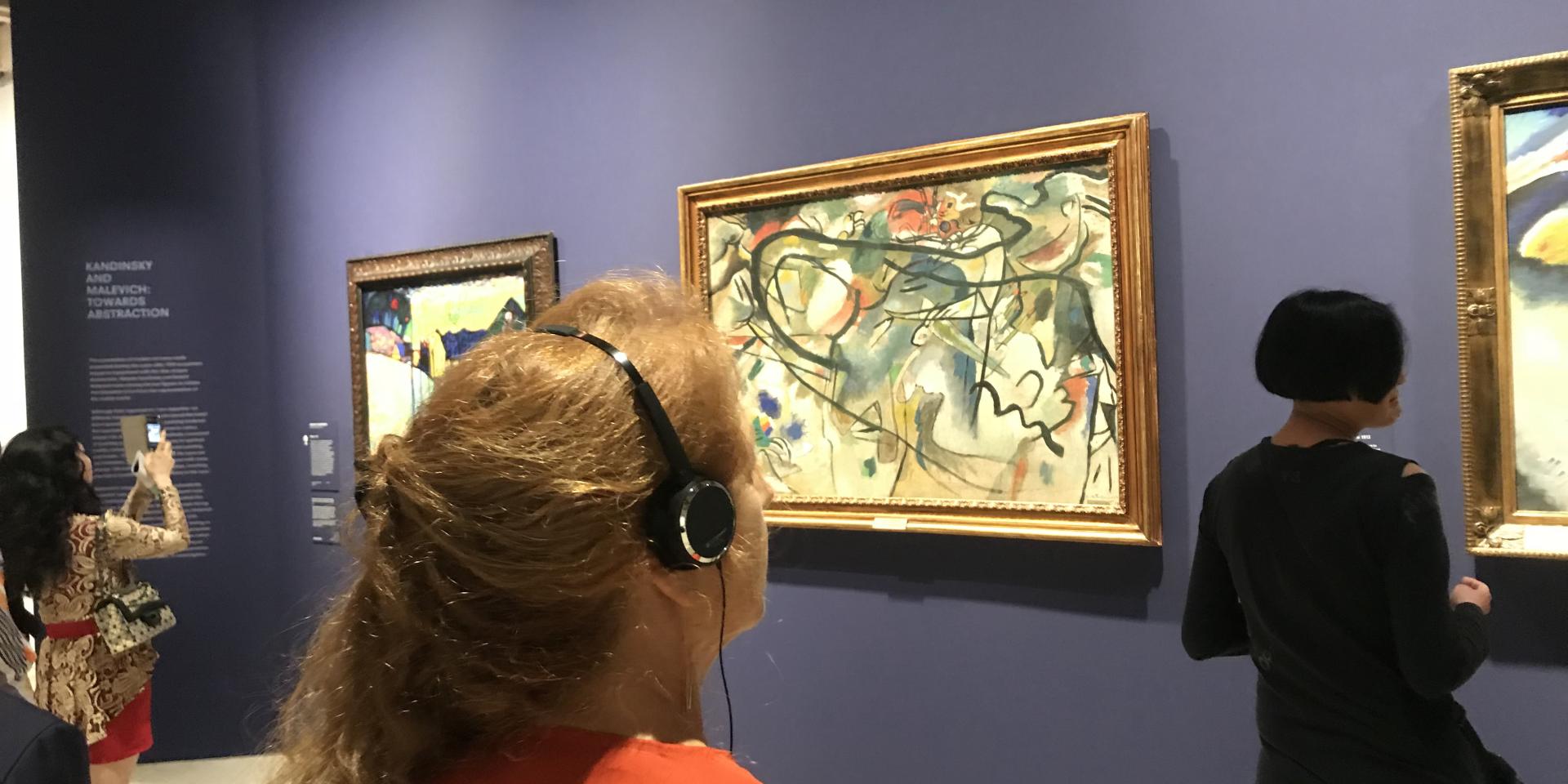 Visitor listening to audio guide at the Hermitage exhibition at the Art Gallery of NSW.