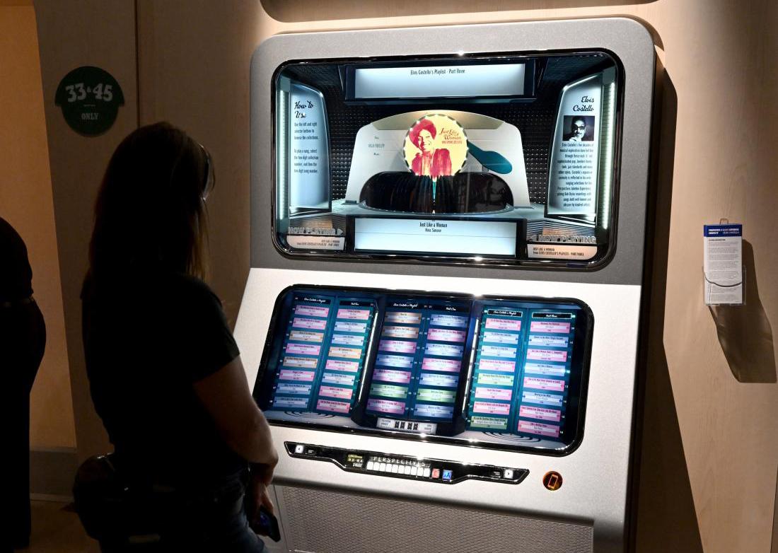 A woman listens to audio played by the Jukebox interactive at the Bob Dylan Center.