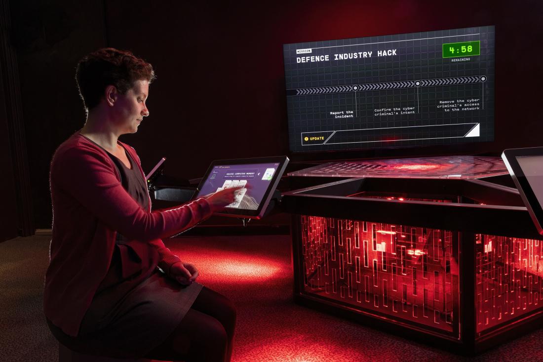 A woman plays an original game Art Processors created for the Decoded exhibition at the National Museum of Australia