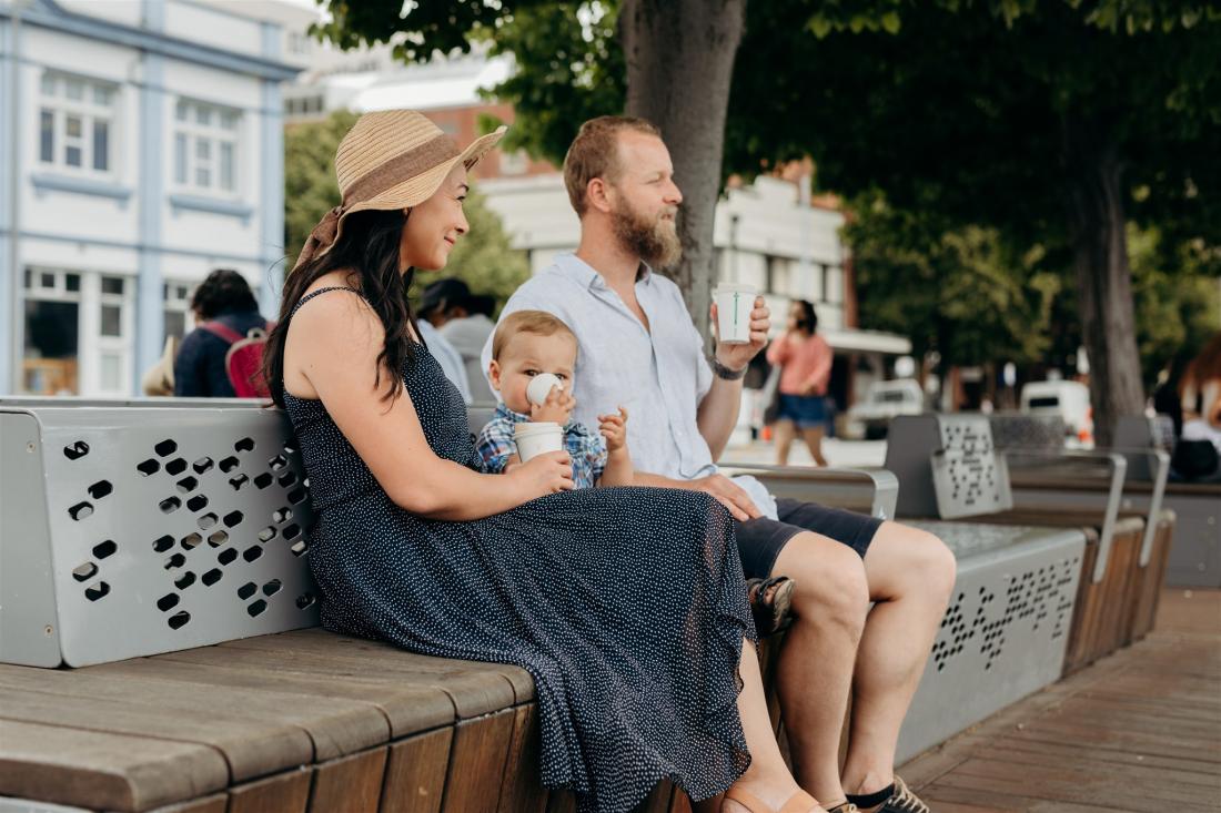 A family enjoy coffees on the Hobart waterfront while waiting to enter the Taste of Summer festival.
